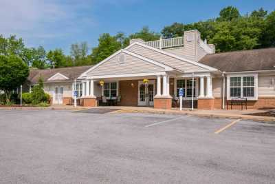 A motel entrance with a parking lot on a clear day.