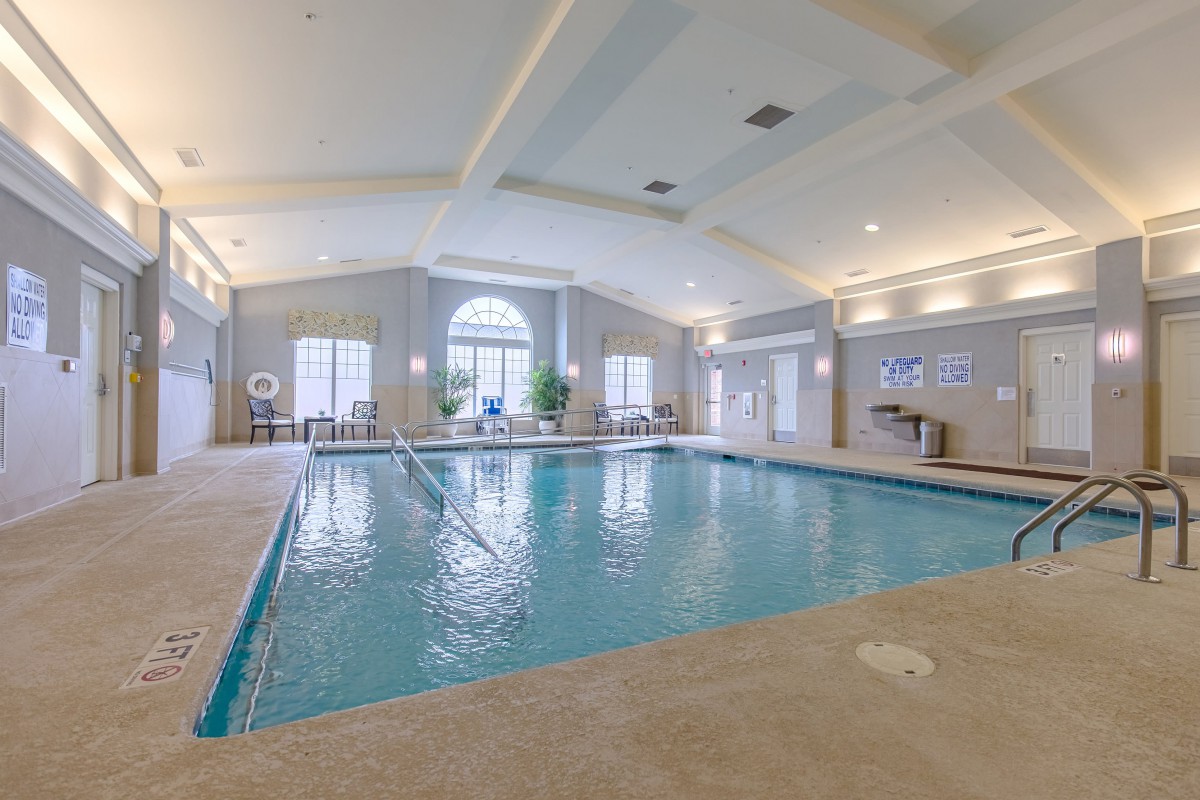 A spacious and well-lit indoor swimming pool area, perfect for relaxation and exercise.