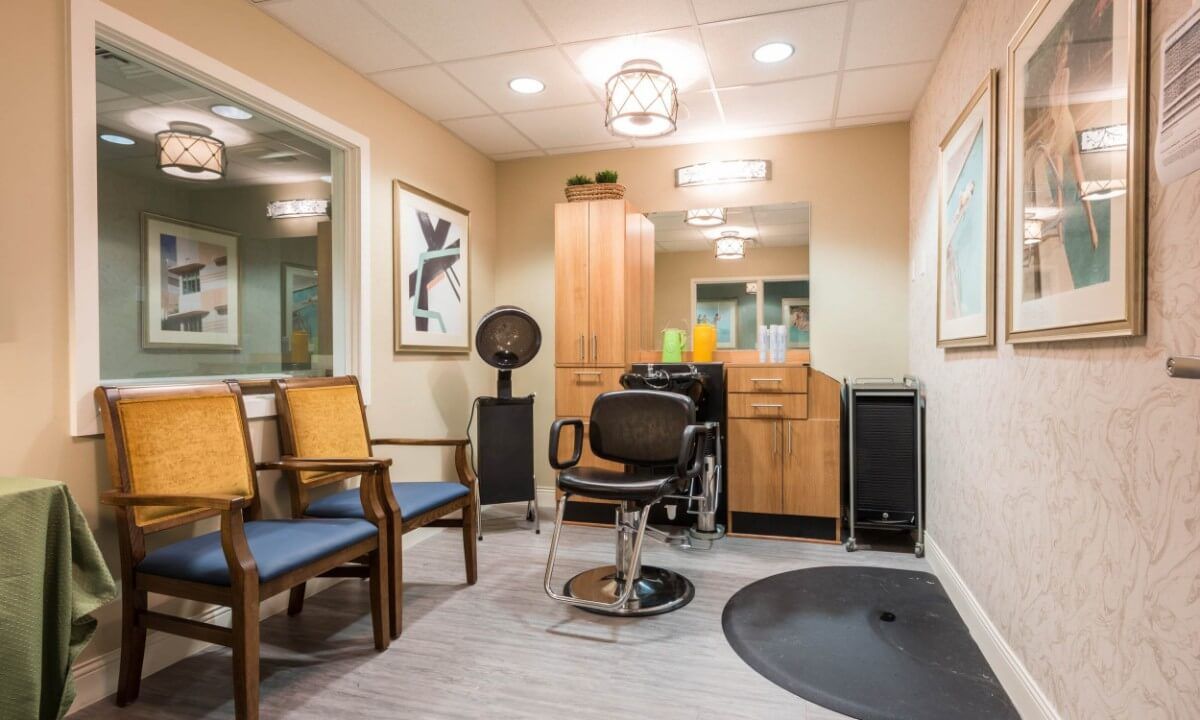 A modern hair salon interior with a styling station and waiting area.