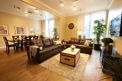 A cozy and elegantly designed living room featuring comfortable leather sofas, a stylish coffee table, and lush indoor plants.