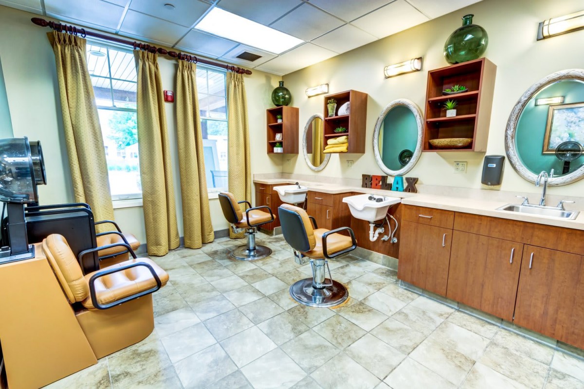 A modern hair salon interior featuring styling chairs, mirrors, and sinks.