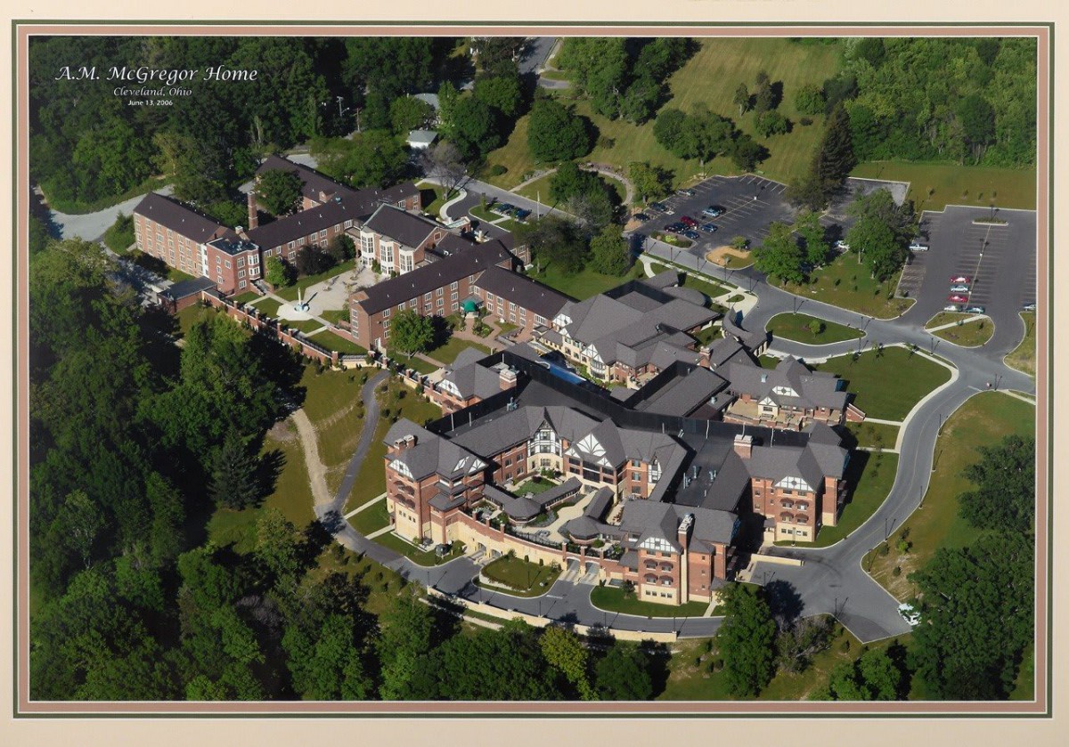 Aerial view of a campus with multiple buildings surrounded by greenery.