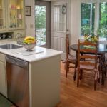 A cozy kitchen with an island and adjacent dining area, featuring a window with a garden view.