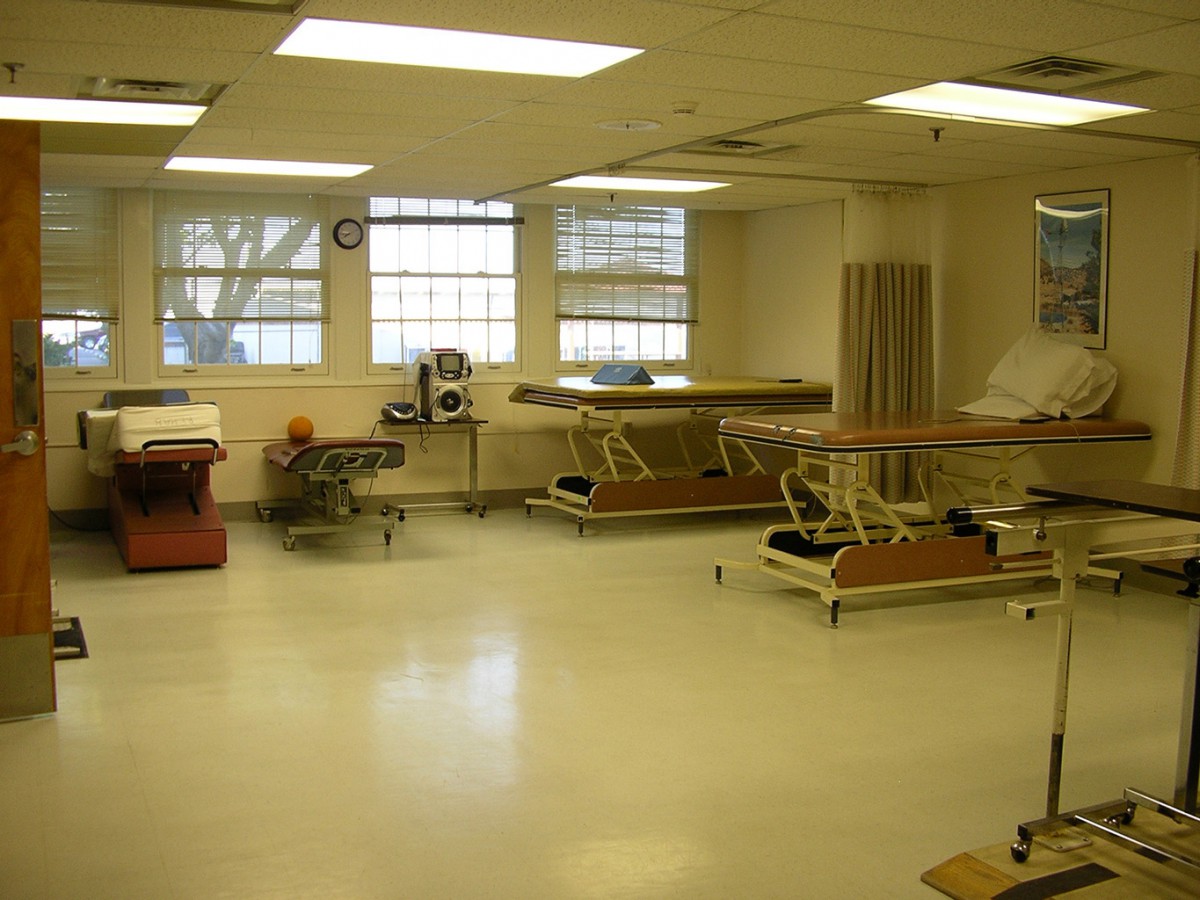 A rehabilitation room equipped with multiple therapy beds and equipment.