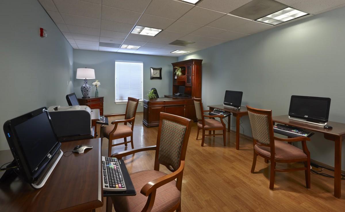 A spacious office room with desks, chairs, and computers.