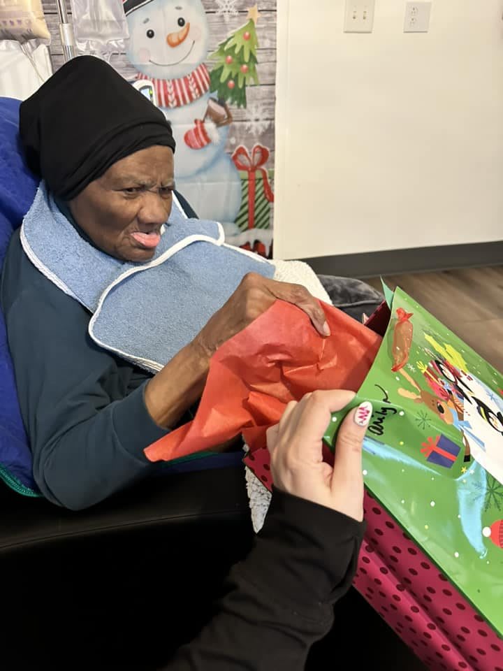A person unwrapping a gift with a smile during a celebration.