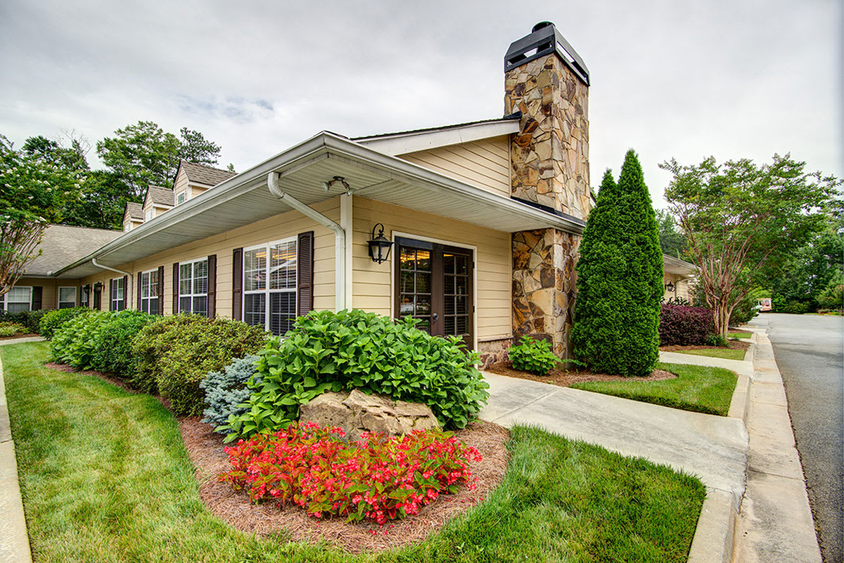 A charming house with a beautiful garden and stone chimney.