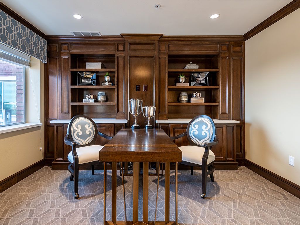A sophisticated home office featuring dark wooden furniture and elegant decorations.
