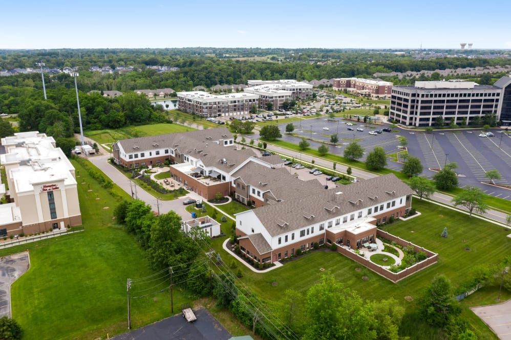 Aerial view of a suburban area with buildings, landscaped surroundings, and parking lots.
