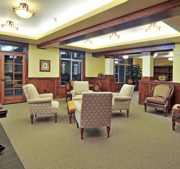 A warm and inviting waiting area with comfortable seating and elegant wood paneling.