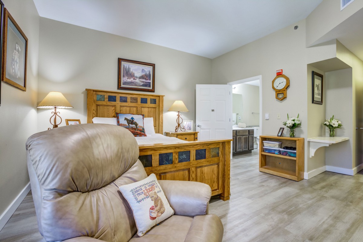 A cozy bedroom with wooden furniture and a comfortable armchair.