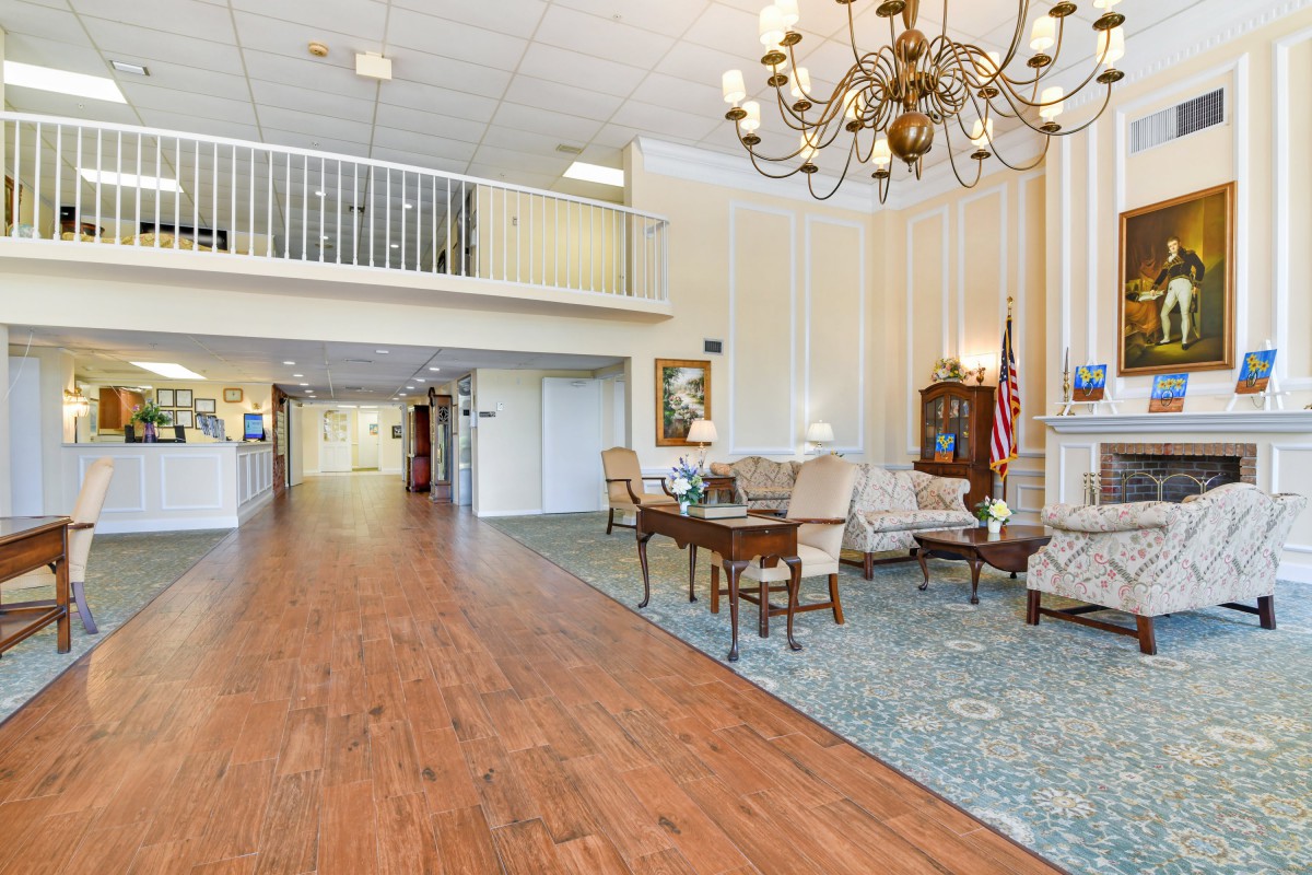 A spacious lobby with elegant decor, featuring a chandelier and comfortable seating area.