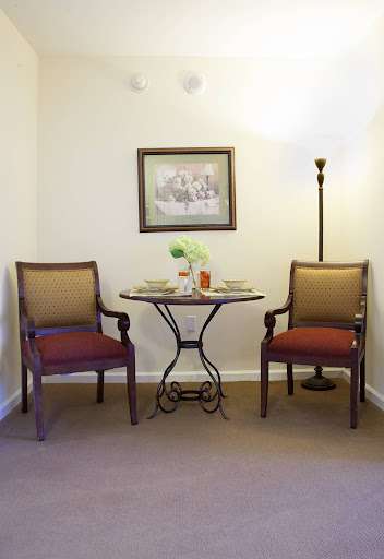 A cozy corner featuring two chairs, a small table with decorative items, and a lamp, perfect for relaxation.