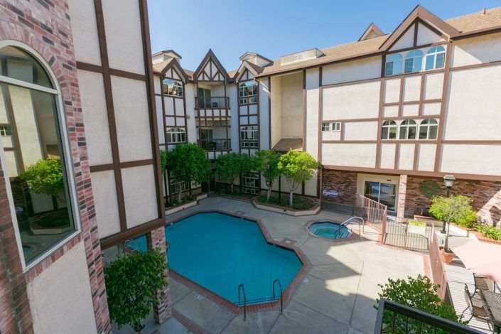 A scenic view of a residential apartment complex with a swimming pool.