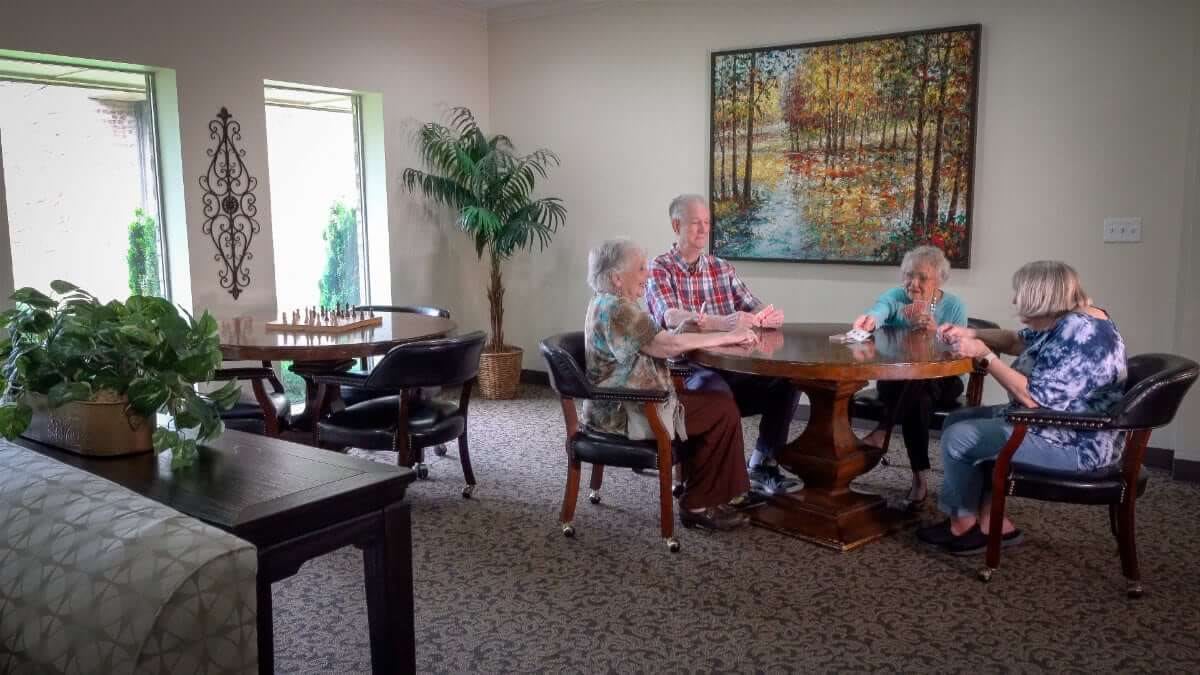 A group of people sitting and talking at a table in a cozy room.