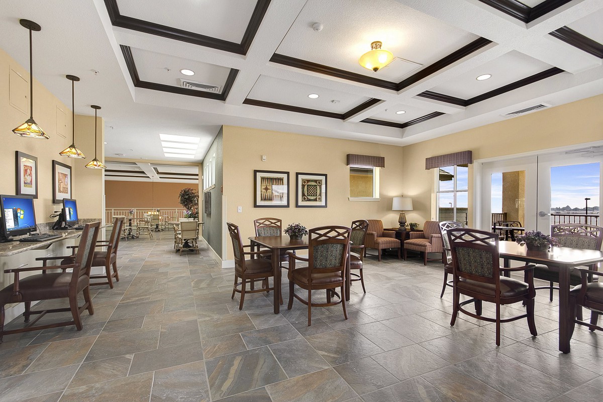 A spacious and contemporary dining area with elegant seating and a coffered ceiling.