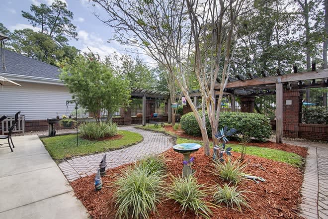 A beautifully landscaped garden with a winding pathway and decorative elements.