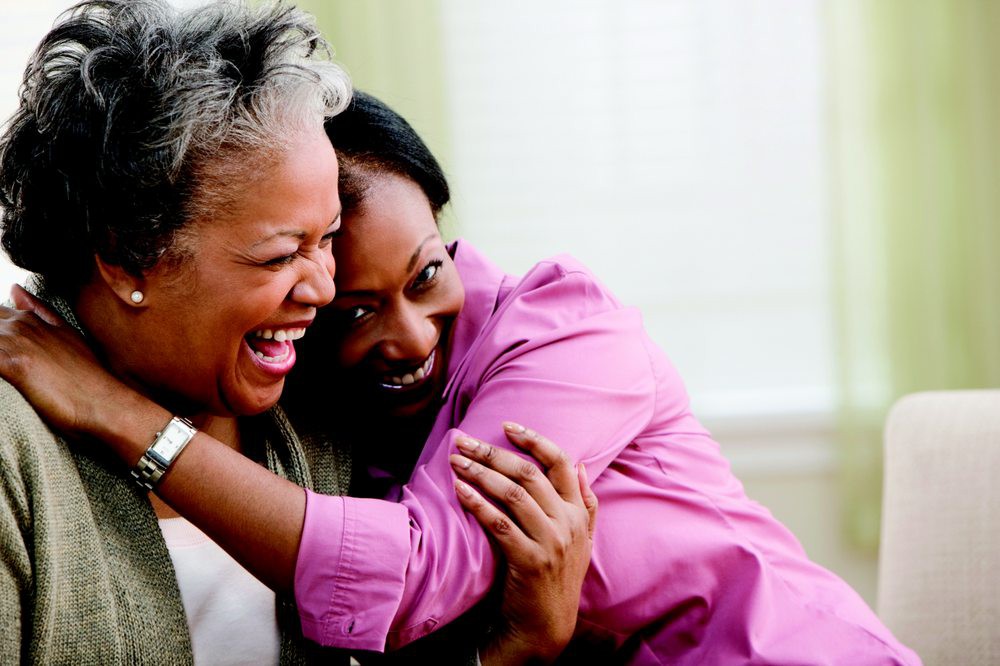 Two people sharing a joyful embrace and laughter.