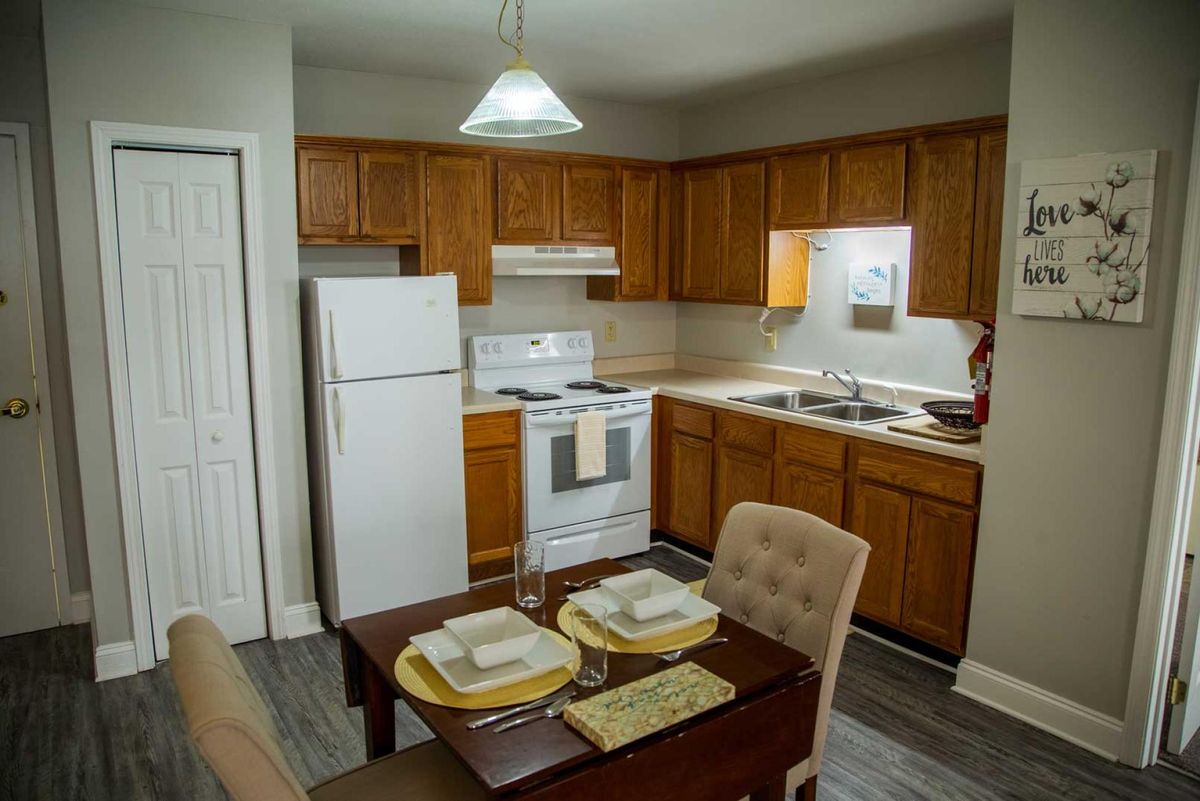 A cozy kitchen and dining area with wooden cabinets and a complete set of appliances.