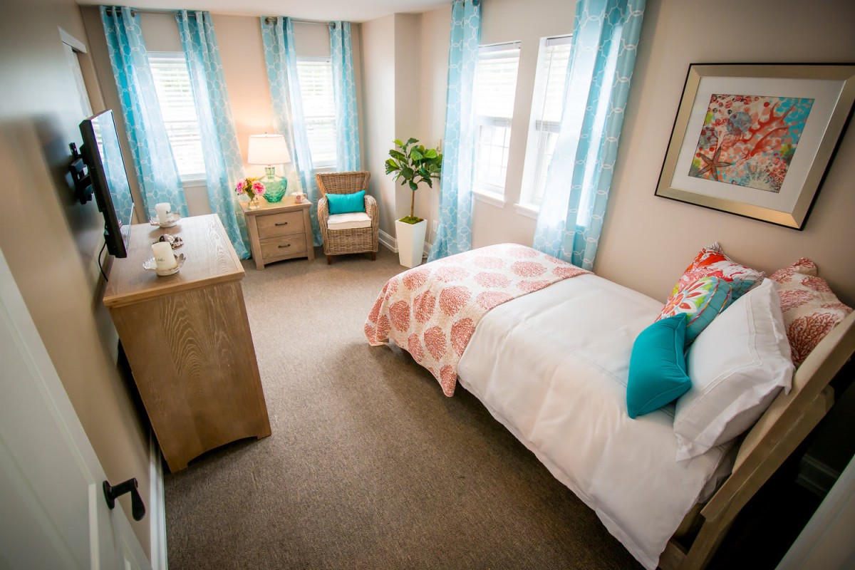 A cozy bedroom with bright natural light, featuring modern decor and comfortable furnishings.