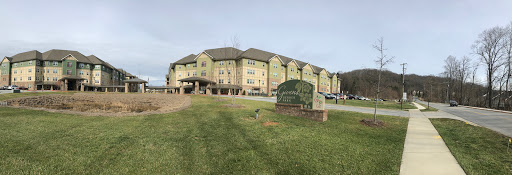A modern residential building with green landscaping in the foreground.