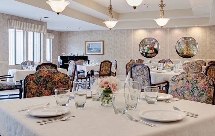An elegantly set dining room with a formal table arrangement and ornate decor.