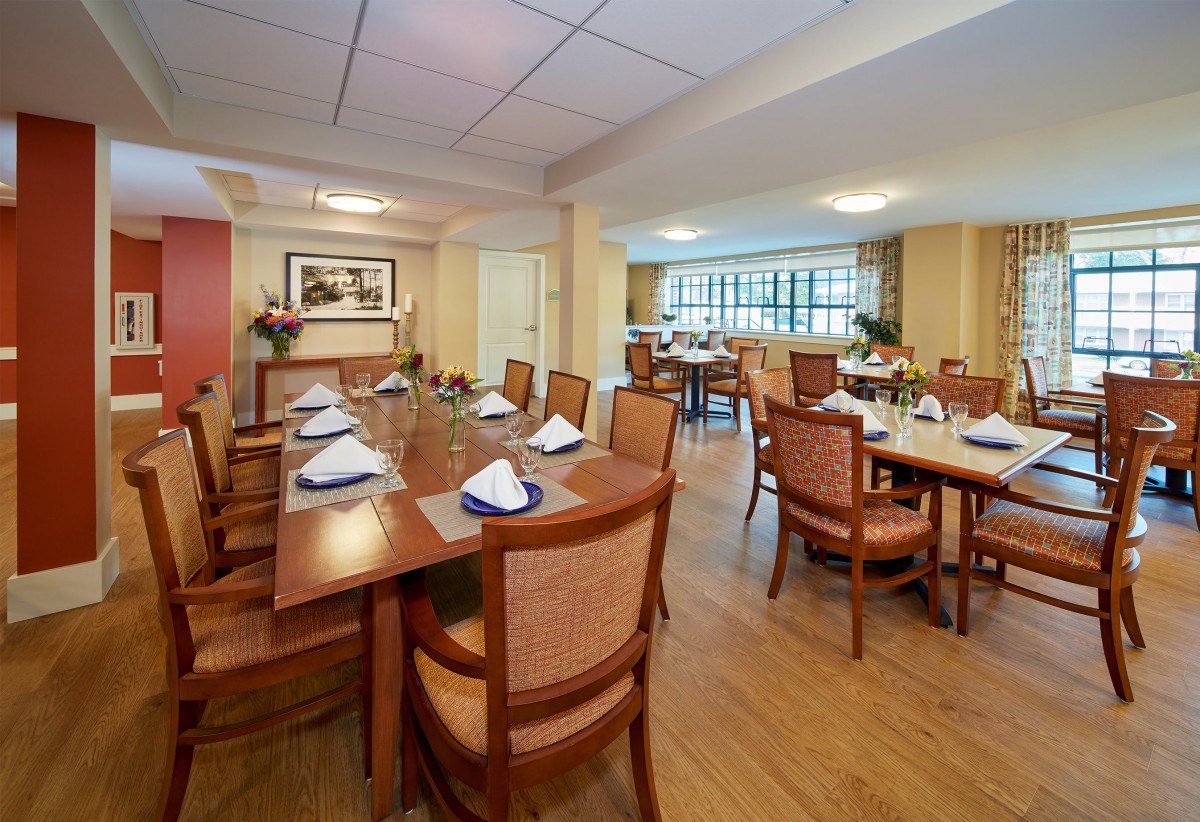 A spacious dining area with neatly arranged tables and chairs, set for a meal.