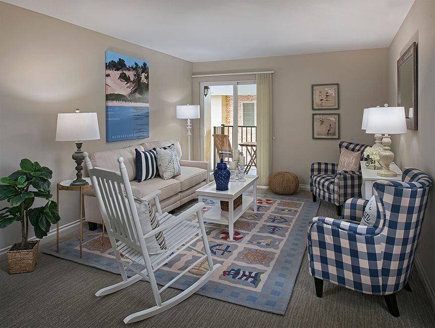 A cozy living room with a rocking chair, sofa, and stylish decor.