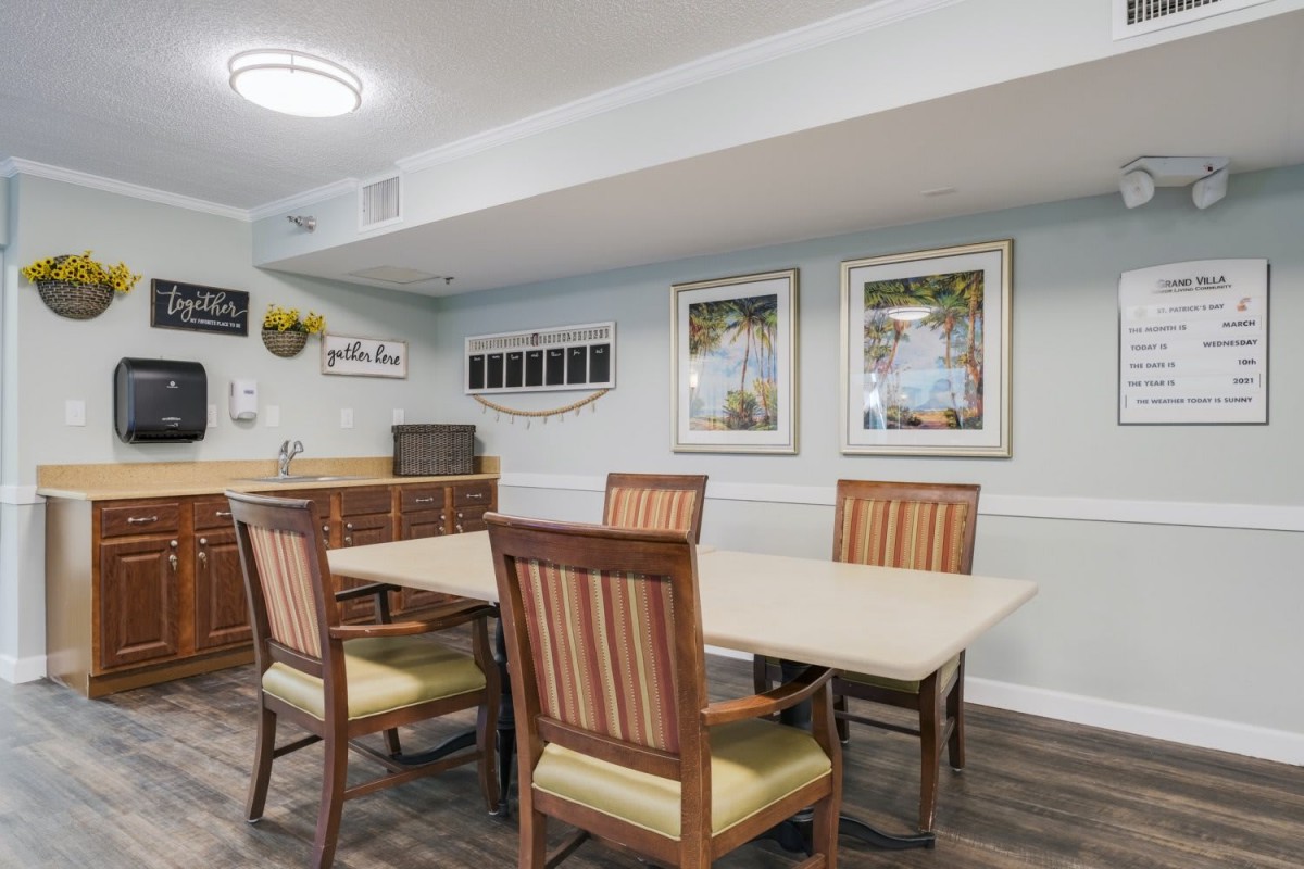 A cozy dining room with a set of wooden chairs and a table, complemented by artwork on the walls and modern lighting.