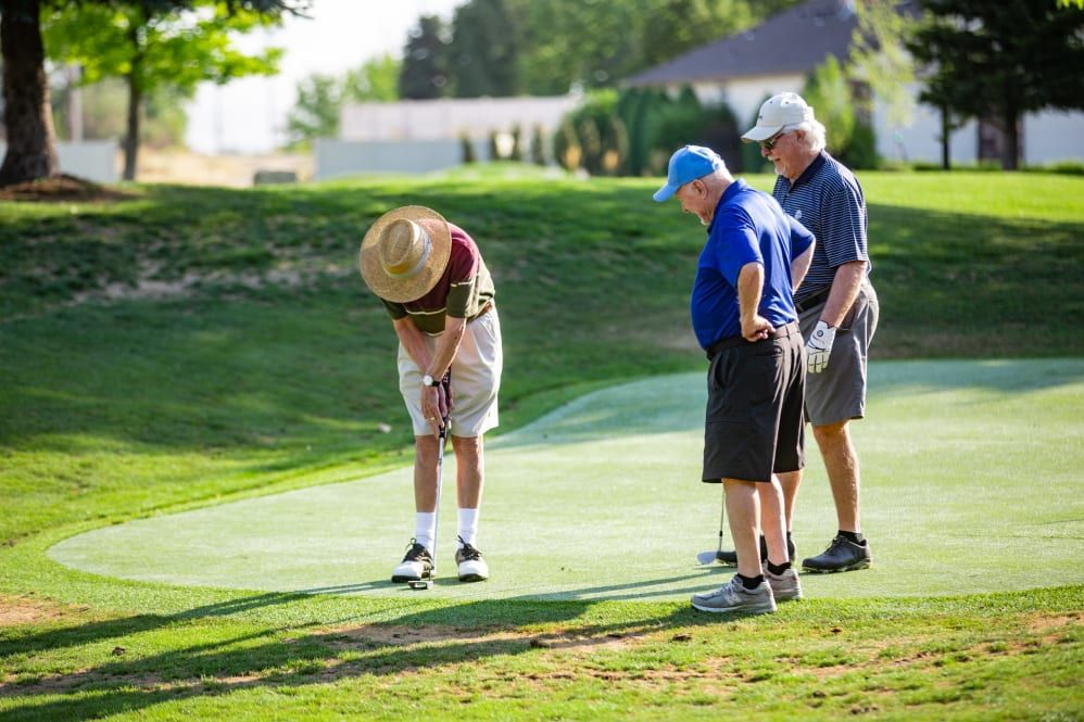 Three men enjoying a game of golf on a sunny day.