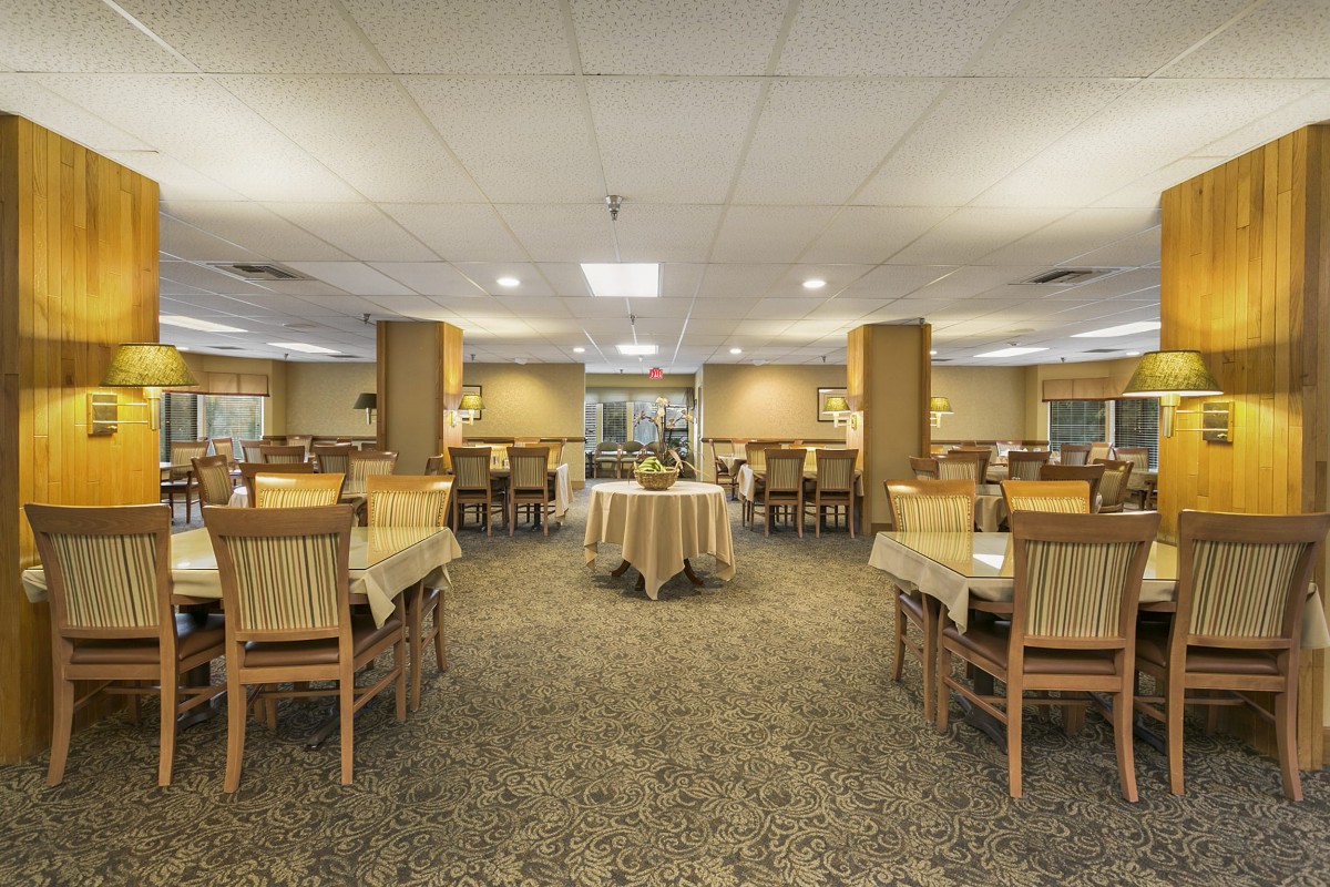 Interior view of a spacious restaurant dining area with neatly arranged tables and chairs.