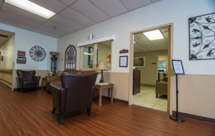 A well-furnished waiting room with comfortable chairs and a reception desk.