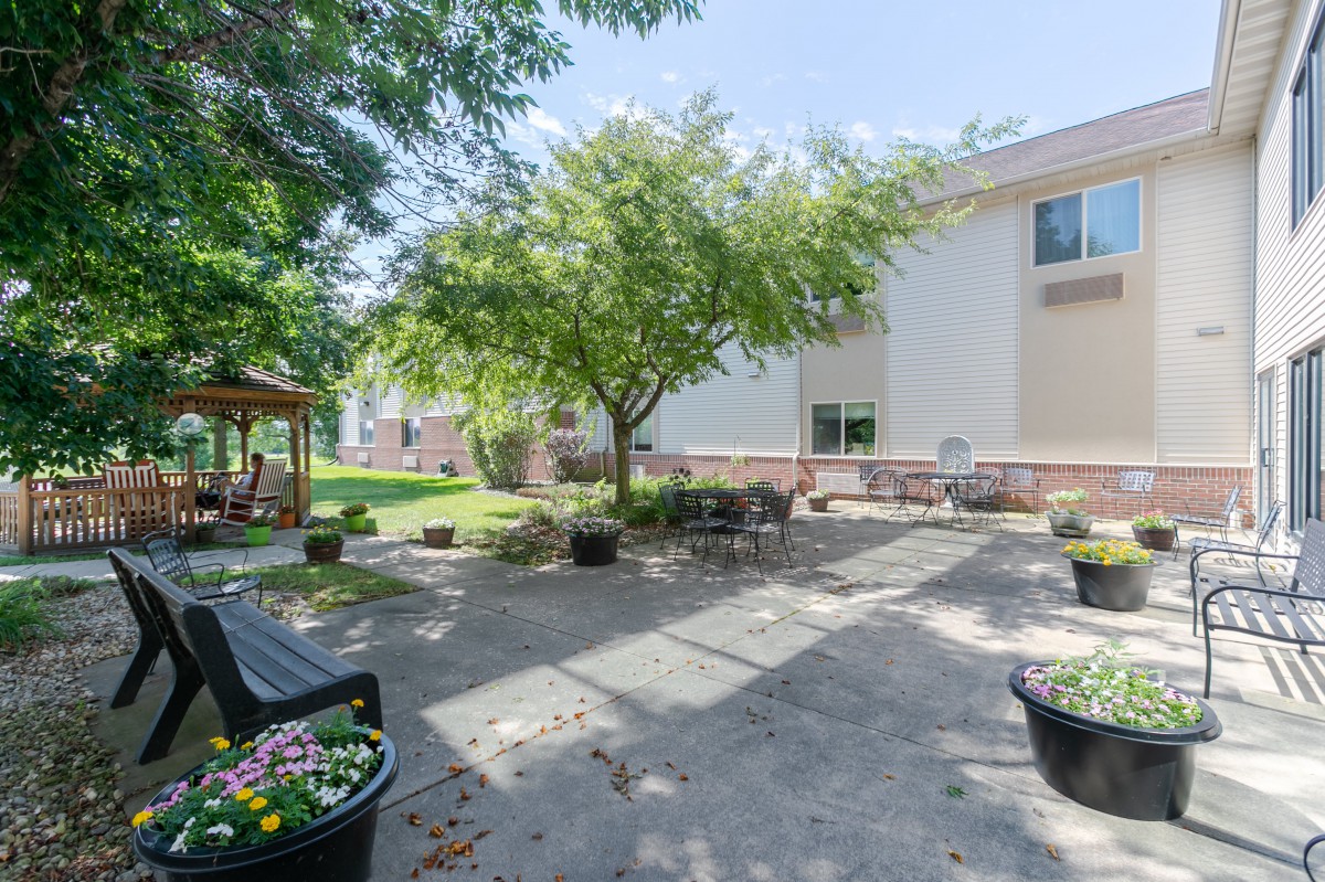 A tranquil outdoor patio area with benches and trees next to a building.