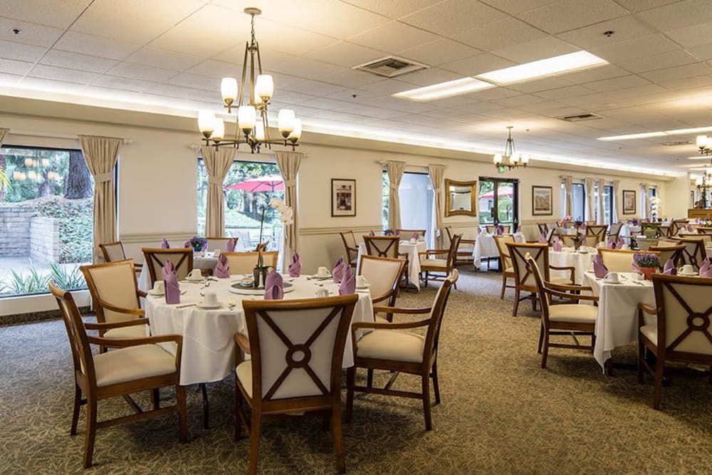 A well-decorated dining room with tables and chairs set for an event.