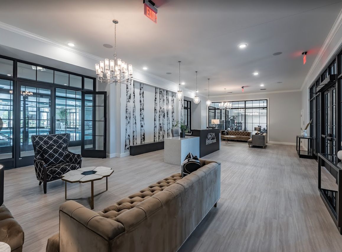 A modern and elegant lobby area featuring comfortable seating, a chandelier, and stylish decor.