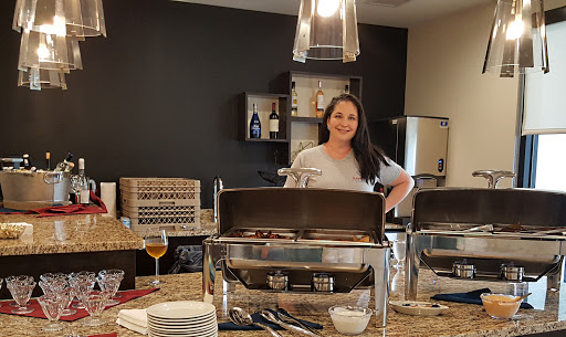 A woman stands confidently in a professional kitchen, ready to serve delicious food.