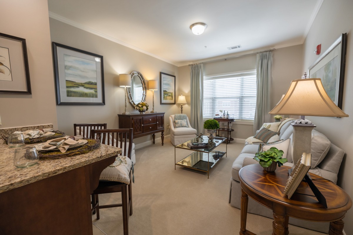 A cozy and well-decorated living room featuring a comfortable sofa, coffee table, stylish furniture, and elegant artwork on the walls.