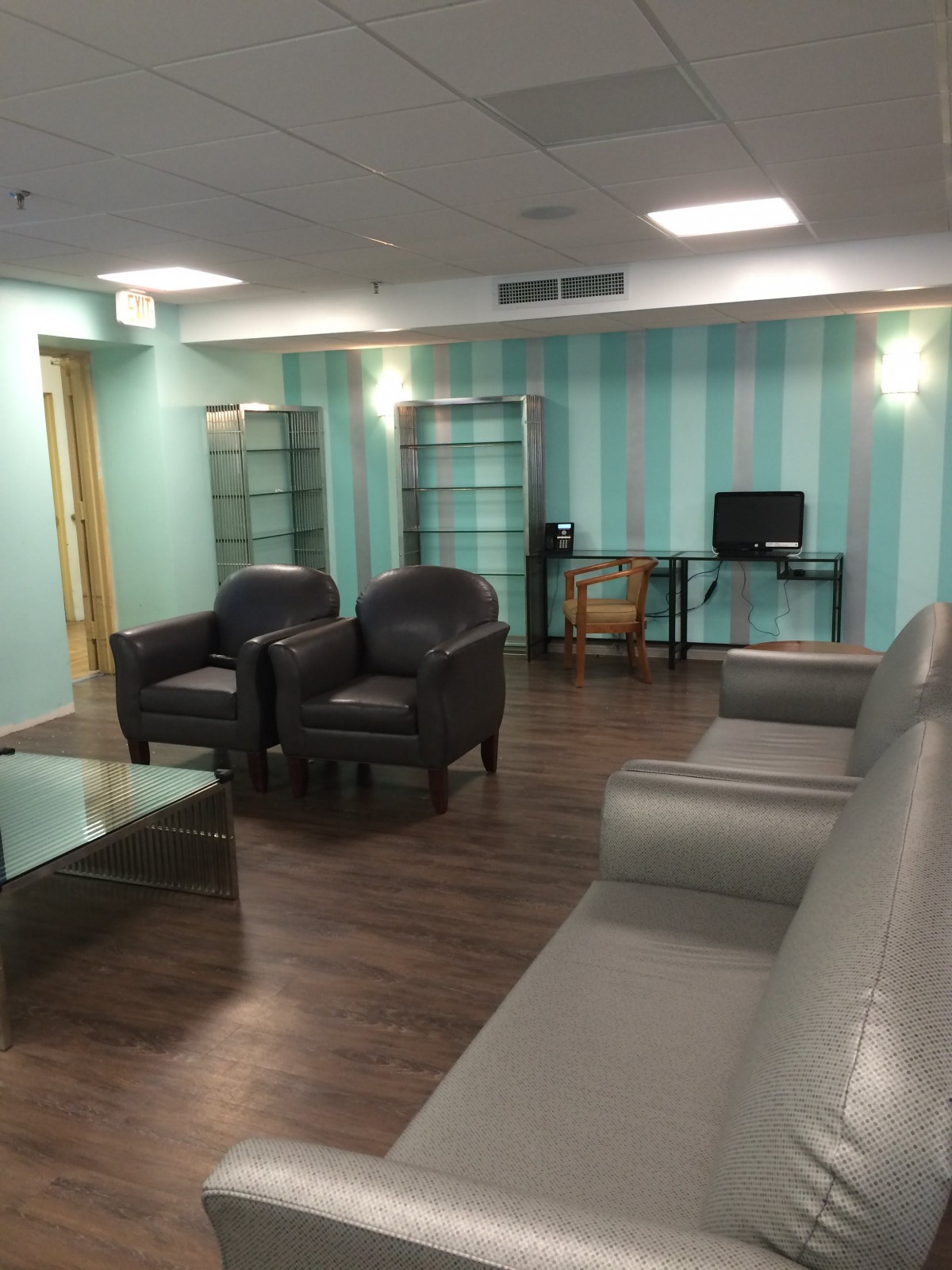 A modern waiting room with comfortable seating and a computer desk.