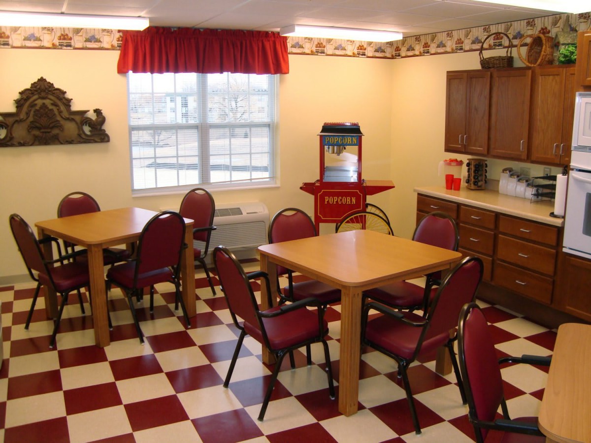 A cozy dining area with checkered flooring and a popcorn machine.