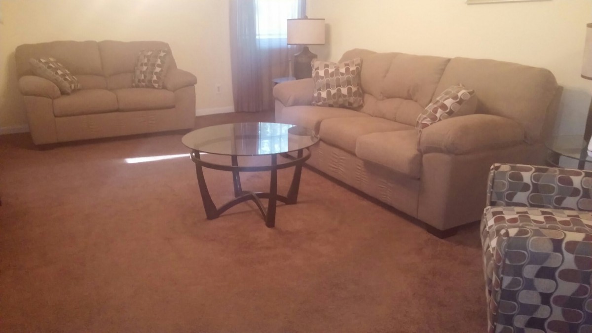 Cozy living room with sofas and a glass coffee table.