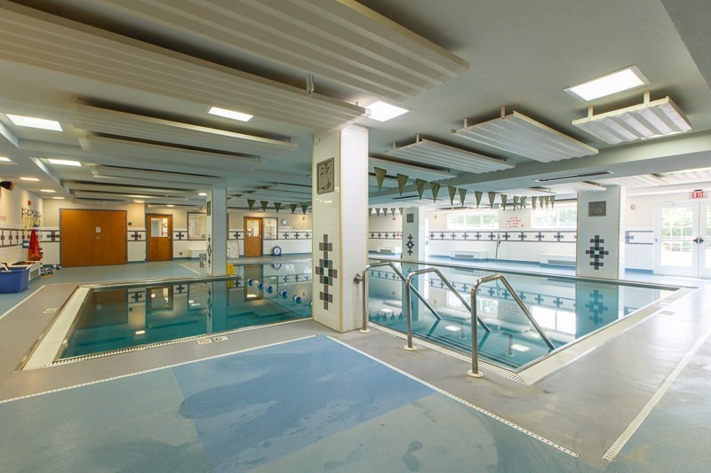 An indoor swimming pool with lane dividers and tiled flooring.