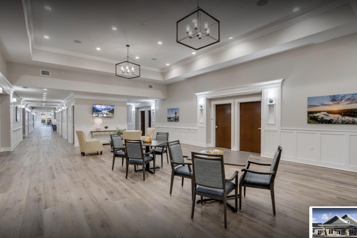A modern interior seating area with tables, chairs, and decorative lighting.