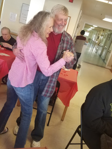 An elderly couple joyfully dancing together at a social gathering.