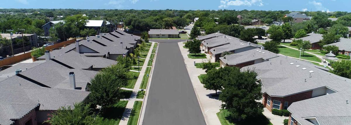 Aerial view of a suburban neighborhood with neatly arranged houses and tree-lined streets.