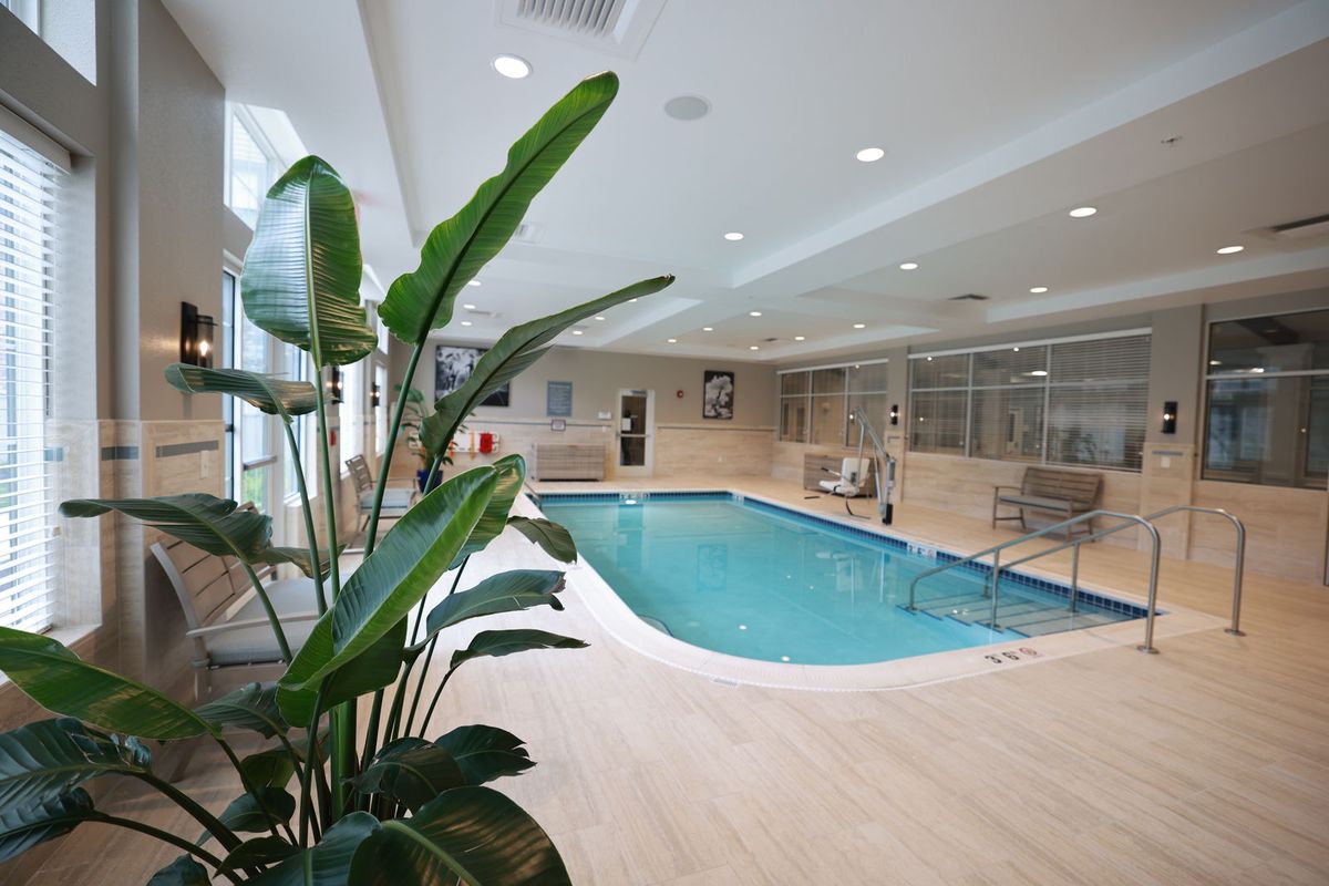 A luxurious indoor pool surrounded by modern amenities and greenery, perfect for relaxation.