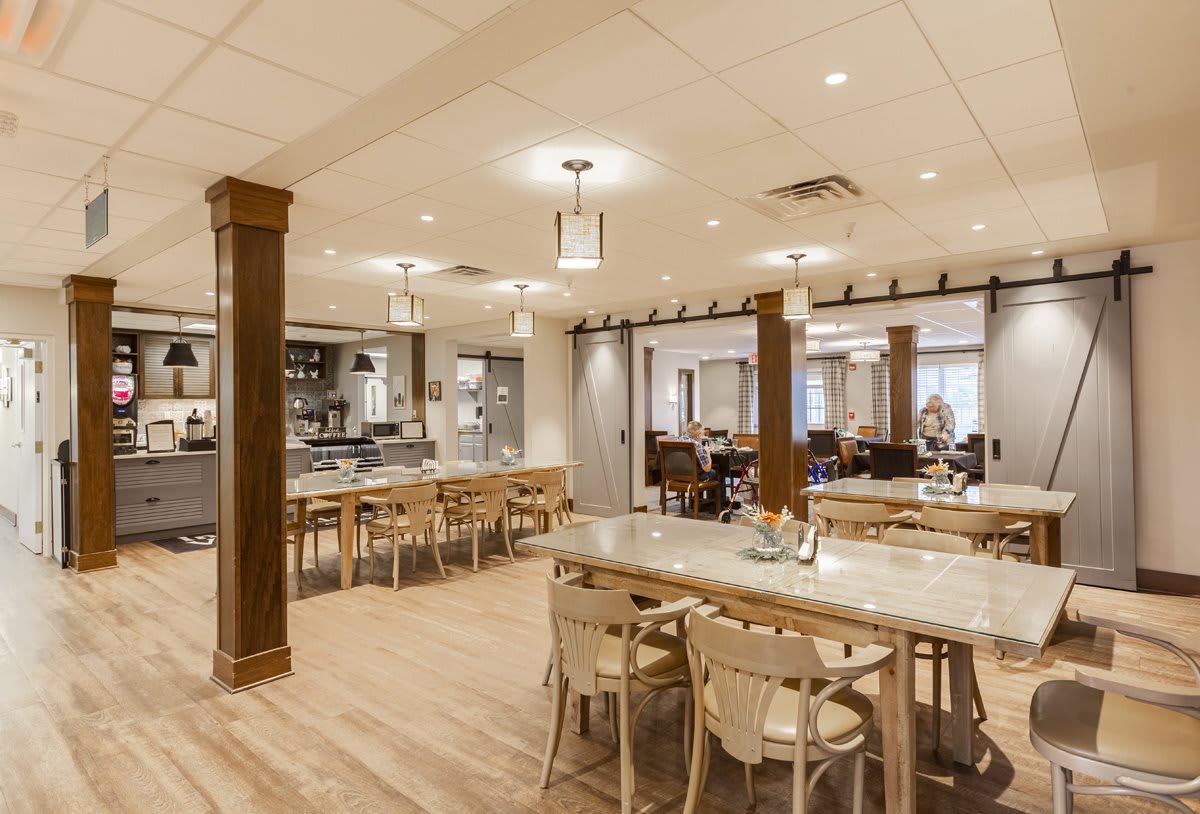 A modern restaurant interior featuring wooden tables, chairs, and soft ambient lighting.