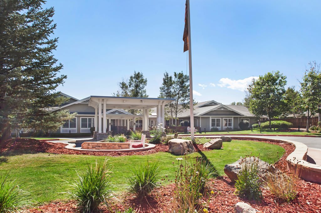 A well-maintained building with a landscaped lawn and clear blue sky.