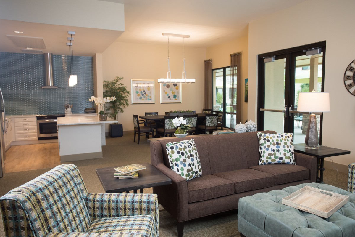 A modern open-space living room featuring a comfortable sofa, dining area, and kitchen.