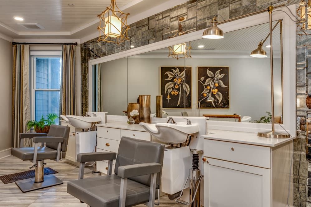 A modern and stylish hair salon interior with comfortable chairs and elegant lighting.