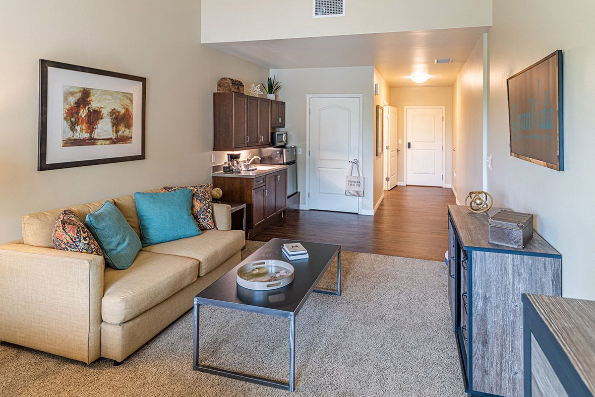 A modern living room with an open floor plan, featuring a comfortable sofa and a sleek coffee table.